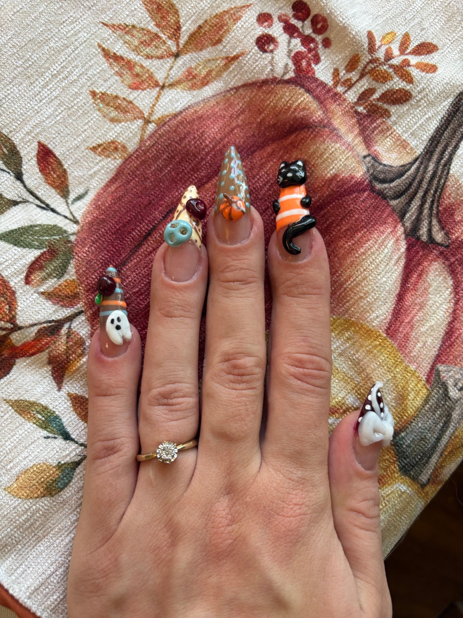 Ongles longs ornés de figurines 3D sur le thème d'Halloween : chat noir, fantôme, chapeau